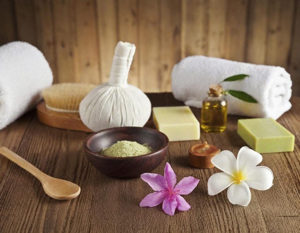 Spa-Stillleben mit Handtüchern, Kräuterstempel und Blüten